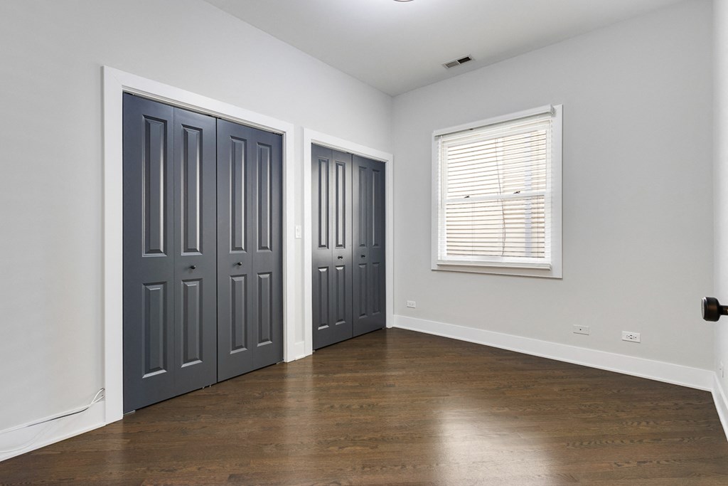 an empty room with two doors and a window