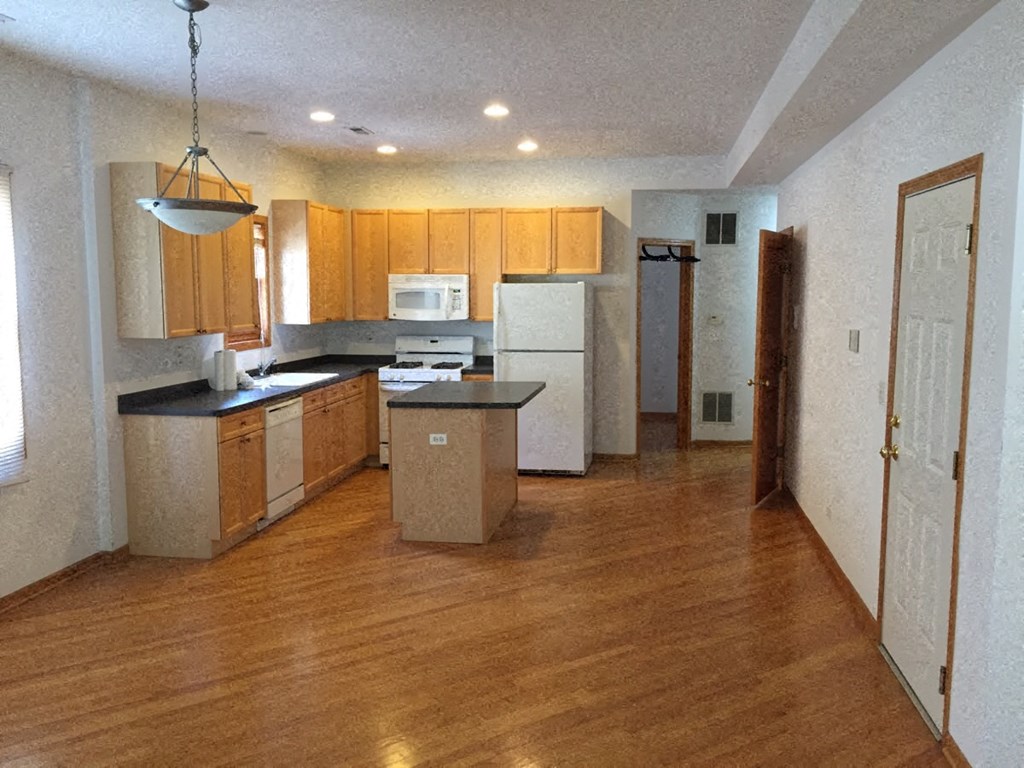 an empty kitchen with a wooden floor and