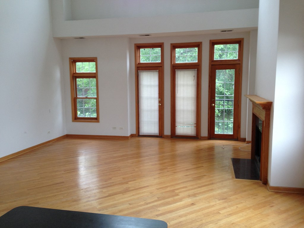 an empty living room with wood floors and windows