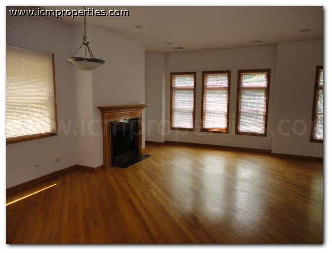 an empty living room with wood floors and a fireplace