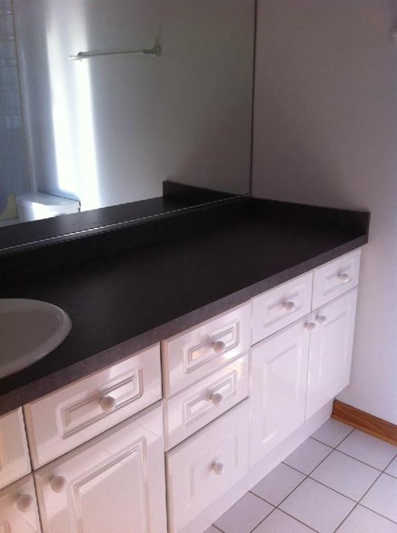 a bathroom with a black counter top and a sink