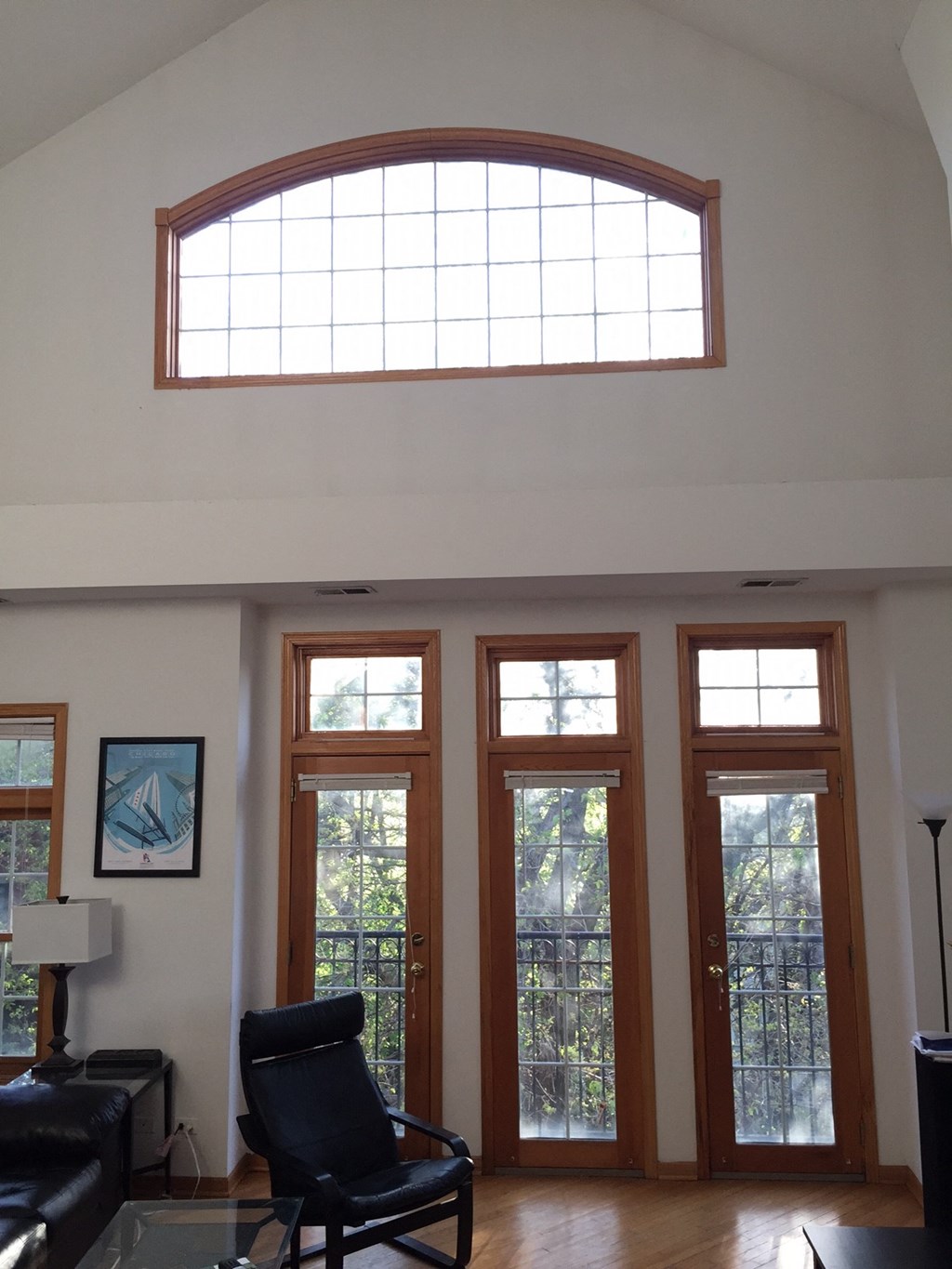 a living room with a large window and a black chair