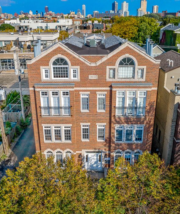 an aerial view of a brick building with a city in the background