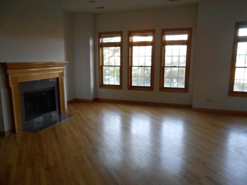 an empty living room with a fireplace and a wooden floor