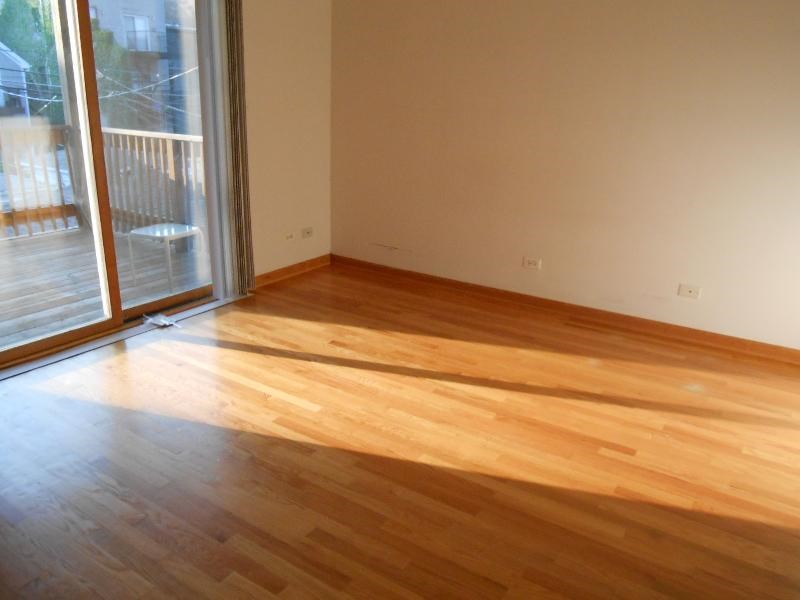 a living room with a wooden floor and a sliding glass door