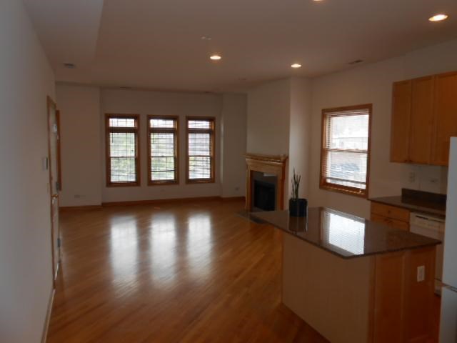 an empty living room with a wood floor and a fireplace