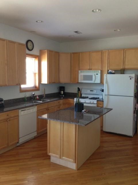 a kitchen with white appliances and wooden cabinets