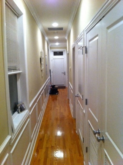 a hallway with a wood floor and white doors