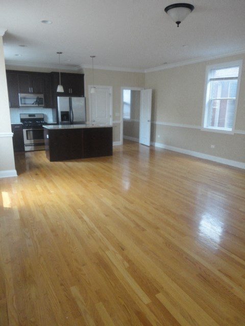 an empty kitchen and living room with wood floors