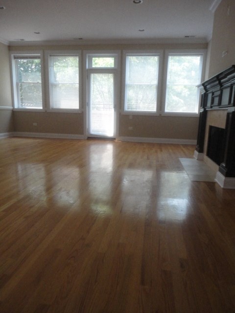 an empty living room with a hard wood floor and windows