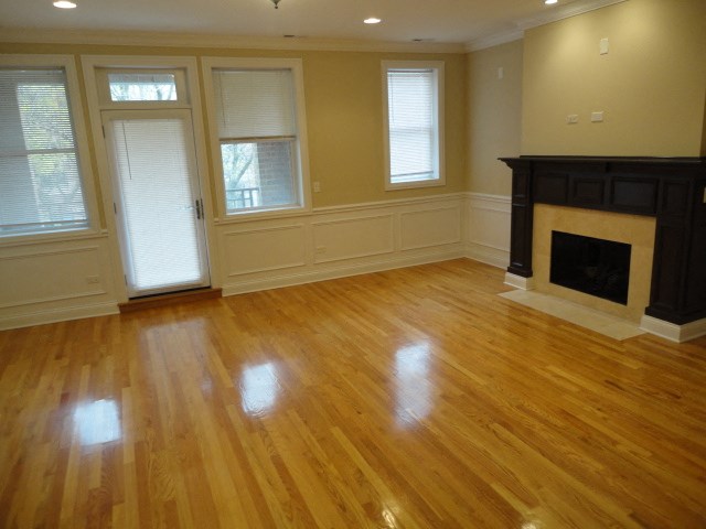 an empty living room with a fireplace and a wooden floor