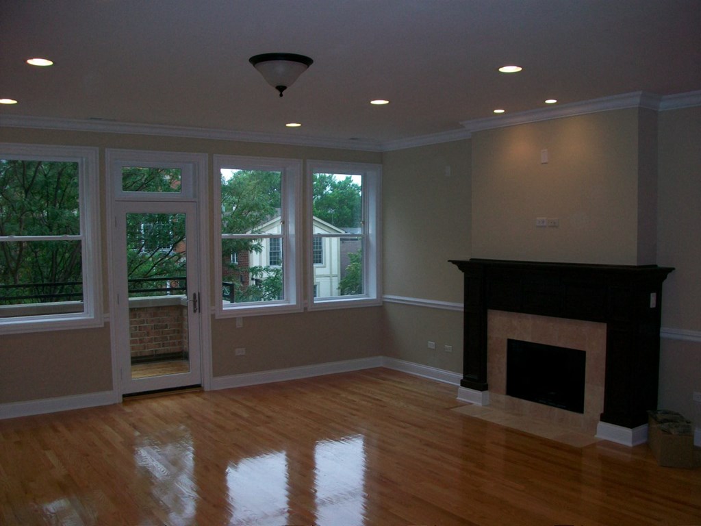 an empty living room with a fireplace and windows