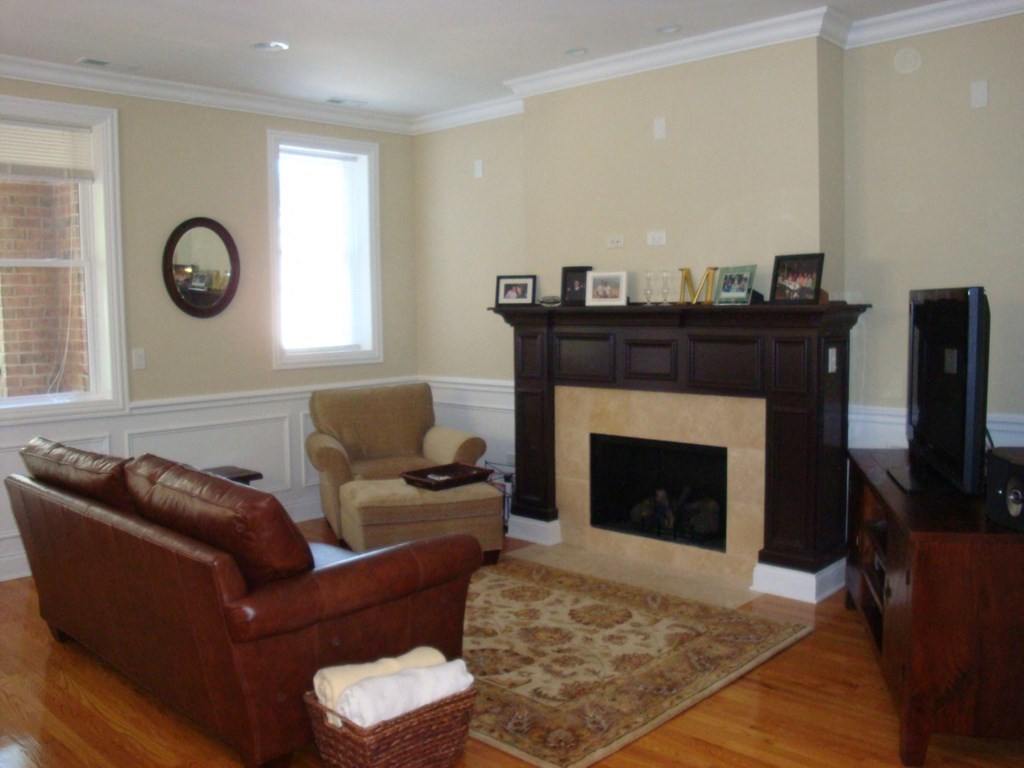 a living room with a fireplace and leather furniture