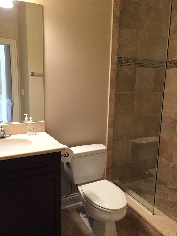 a bathroom with a shower and a toilet and a sink