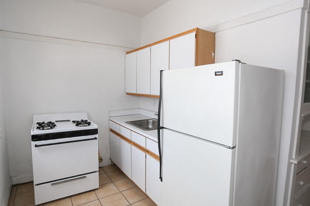 an empty kitchen with a stove refrigerator and sink