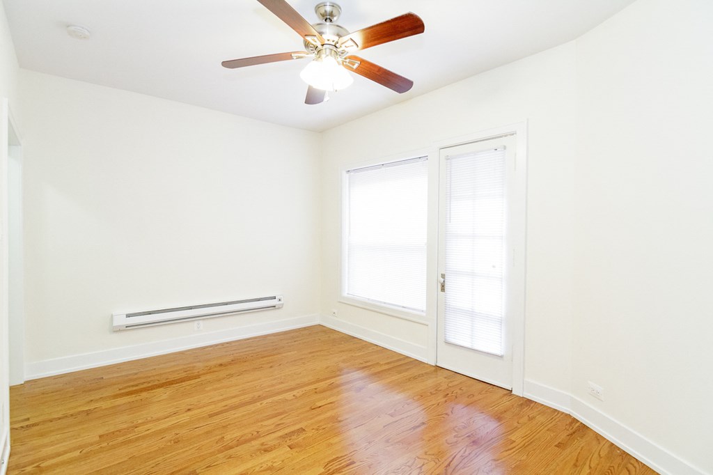 a living room with wood floors and a ceiling fan
