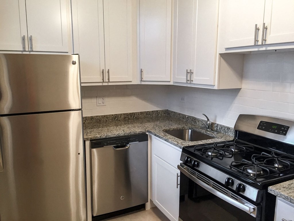 a kitchen with stainless steel appliances and white cabinets