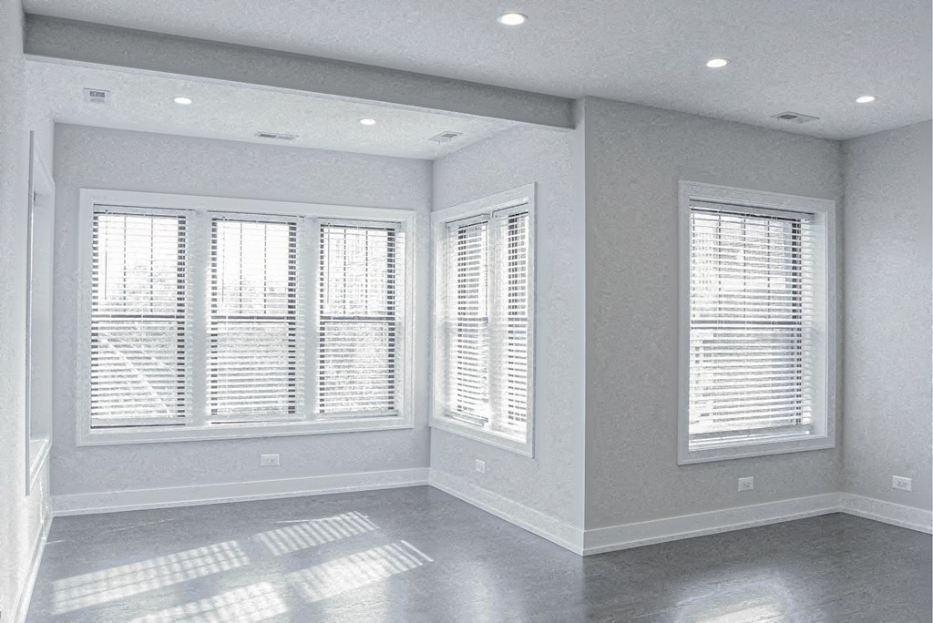 an empty living room with white windows