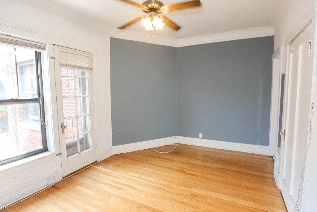 an empty room with blue walls and a ceiling fan
