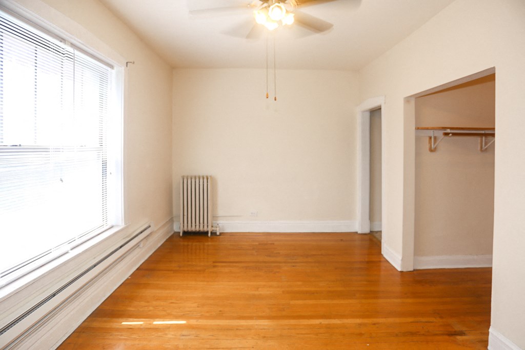 an empty living room with wood floors and a large window