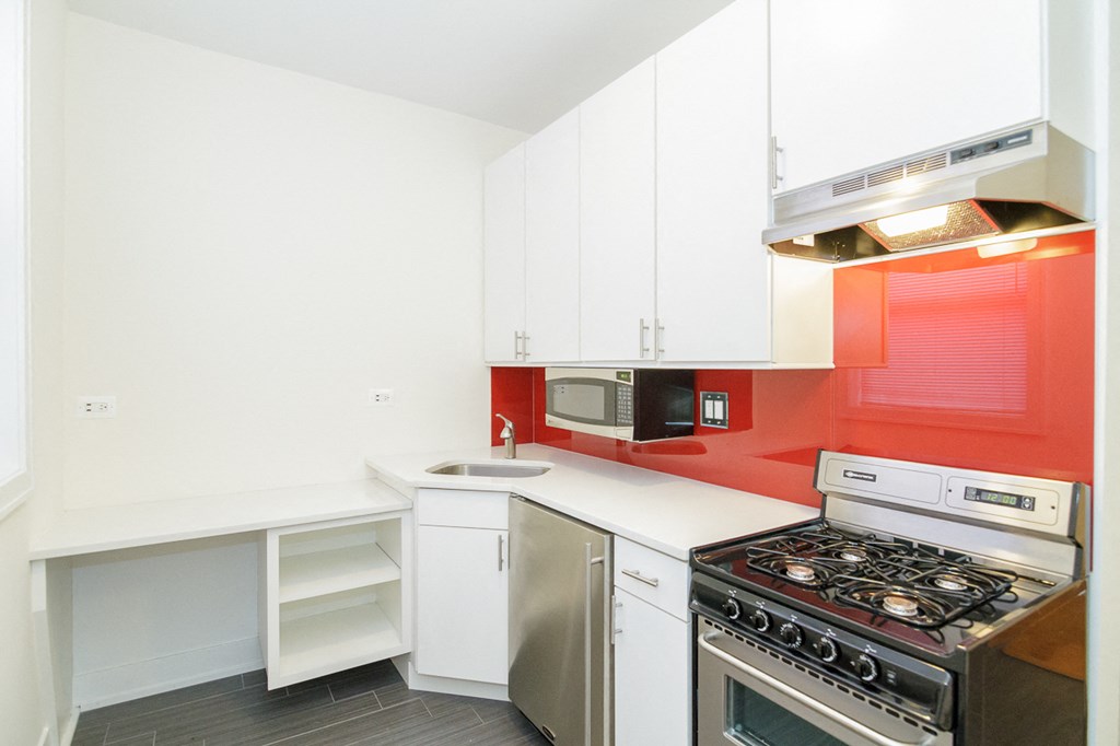a kitchen with white cabinets and a stove and a microwave