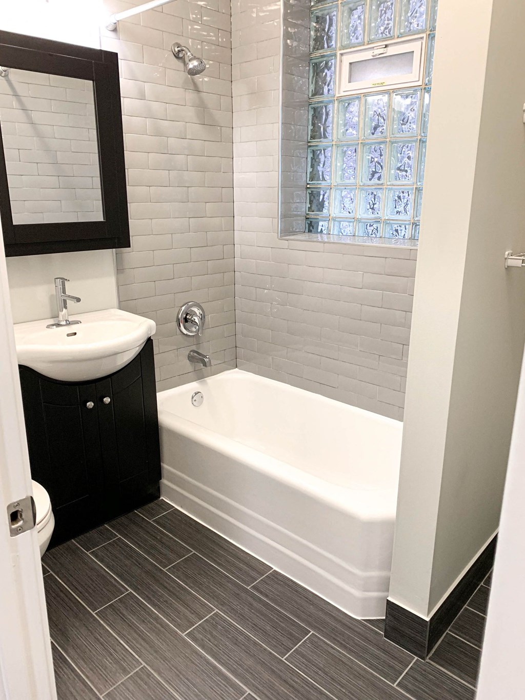 a bathroom with a tub and a sink and a mirror