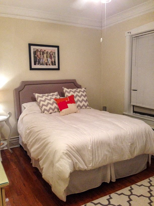 a bedroom with a bed with white sheets and pillows