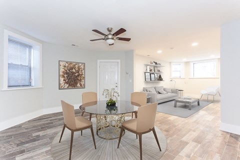 a living room with a dining room table and a ceiling fan