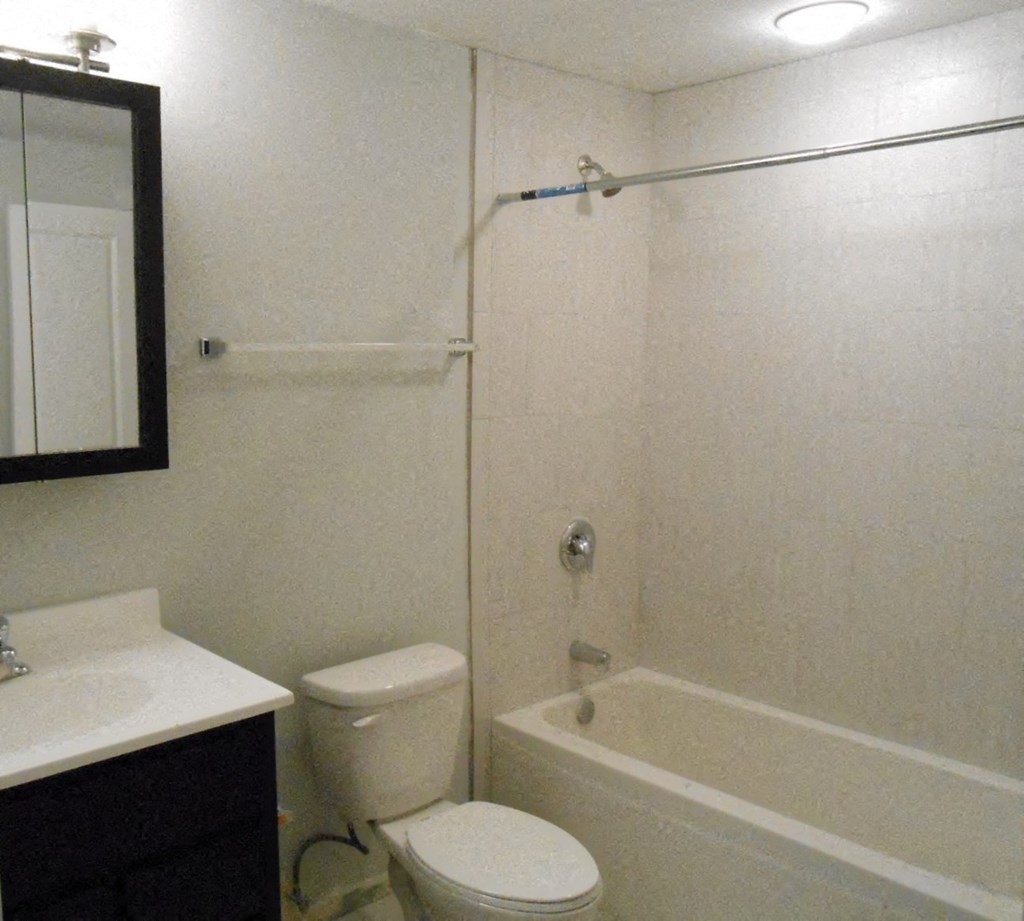 a bathroom with a toilet and a tub and a sink