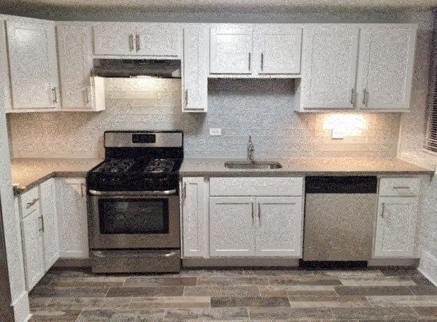a kitchen with white cabinets and a stove and a sink