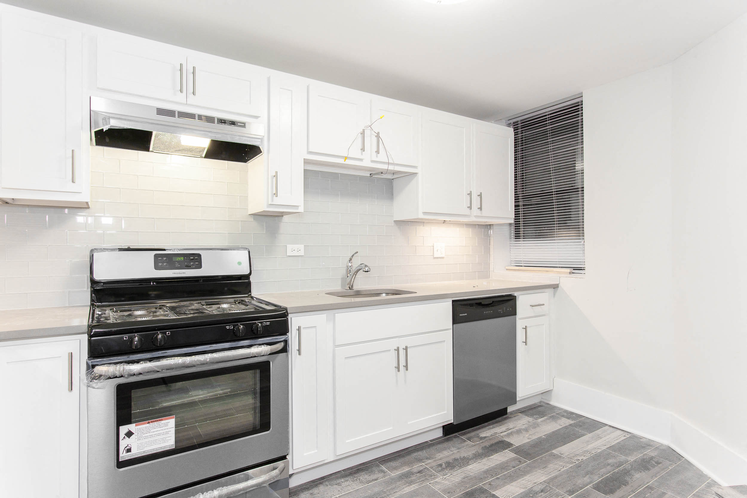 a kitchen with white cabinets and black appliances