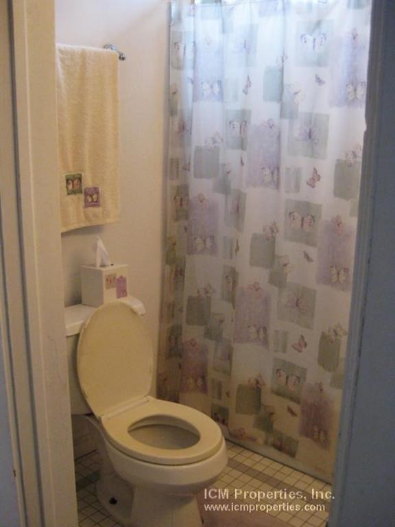 a bathroom with a toilet and a shower curtain