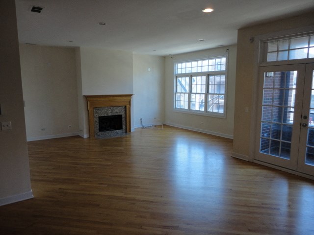 an empty living room with wood floors and a fireplace
