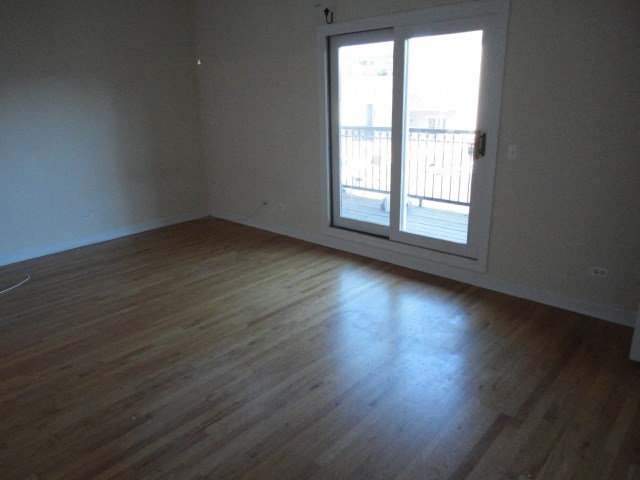 an empty living room with a door to a balcony