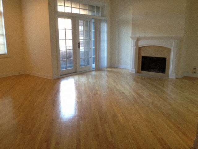 a living room with a hard wood floor and a fireplace