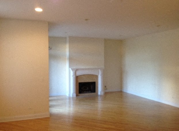 a living room with white walls and a fireplace
