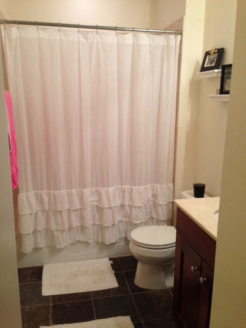 a bathroom with a white shower curtain and a toilet