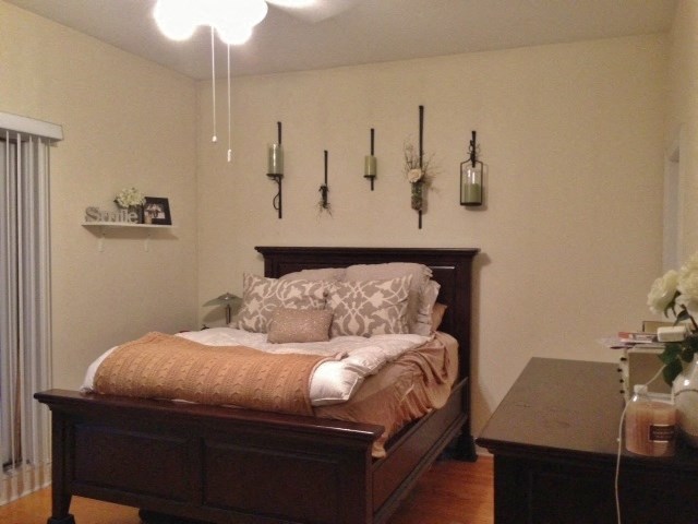 a bedroom with a bed and lamps on the wall