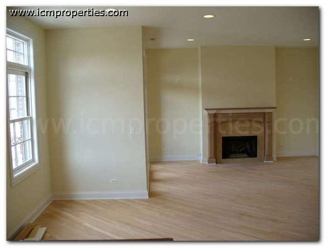 a empty living room with a fireplace and wooden floors