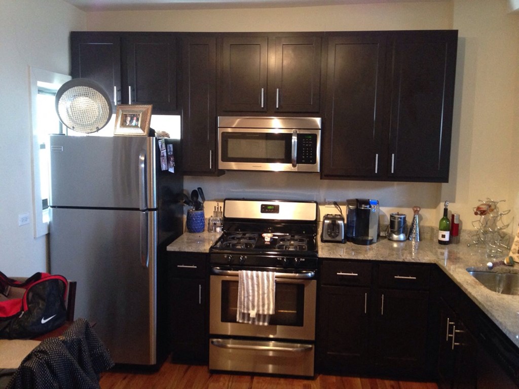 a kitchen with stainless steel appliances and black cabinets