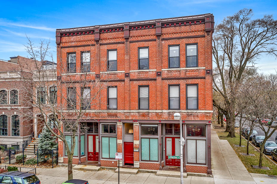 a red brick building with green and red doors