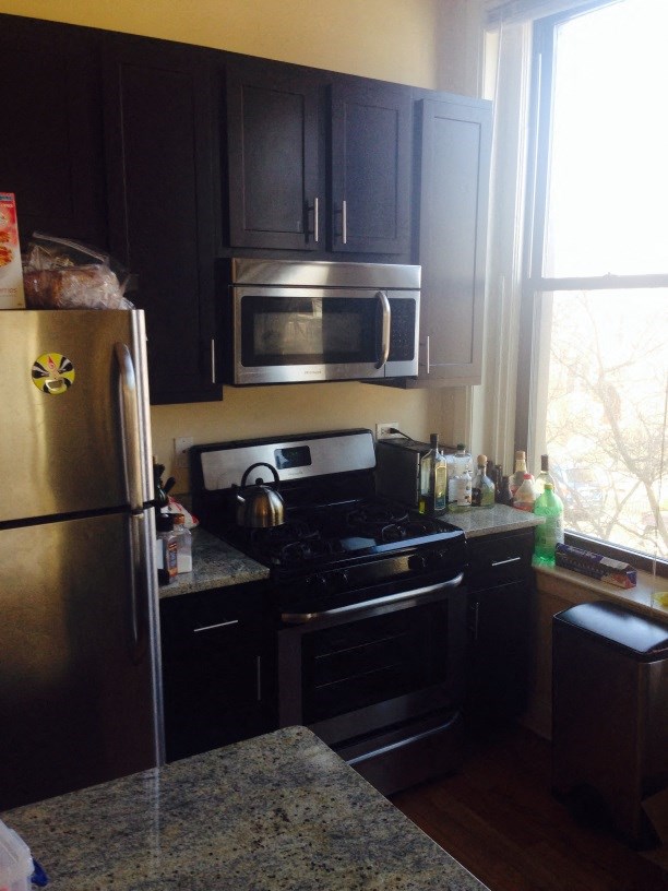 a kitchen with stainless steel appliances and black cabinets