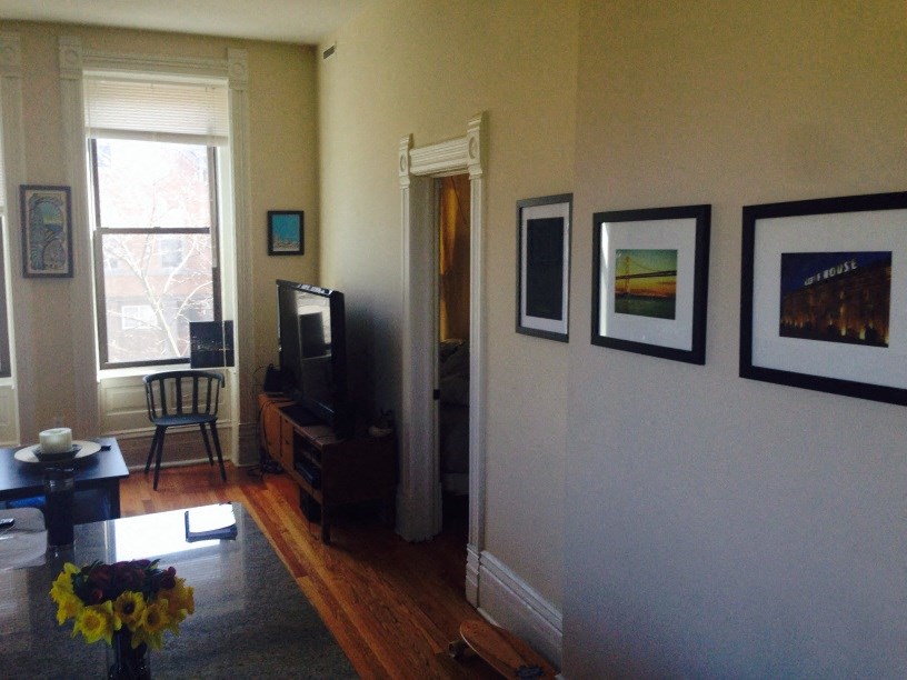 a living room with pictures on the wall and a tv