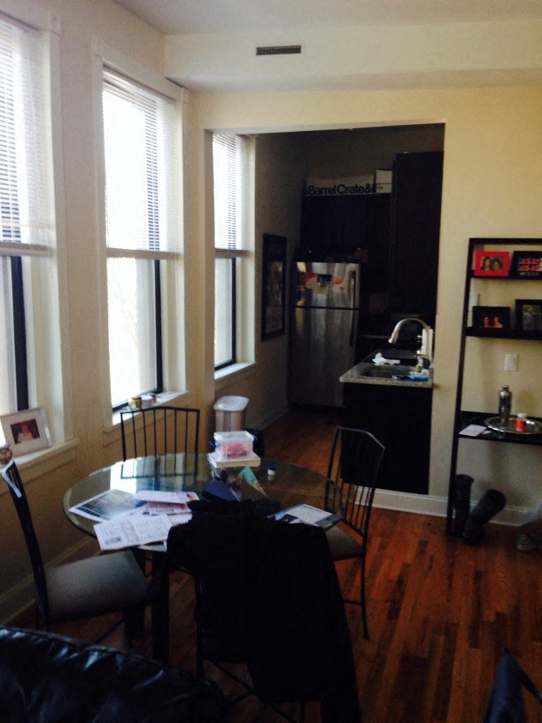 a living room with a table and chairs and a kitchen