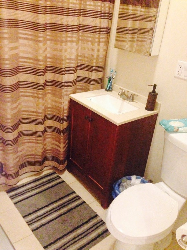 a bathroom with a toilet and a sink and a shower curtain
