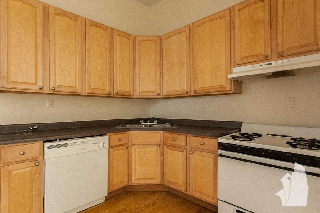 a kitchen with white appliances and wooden cabinets