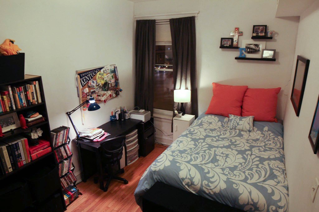 a small bedroom with a bed and a desk