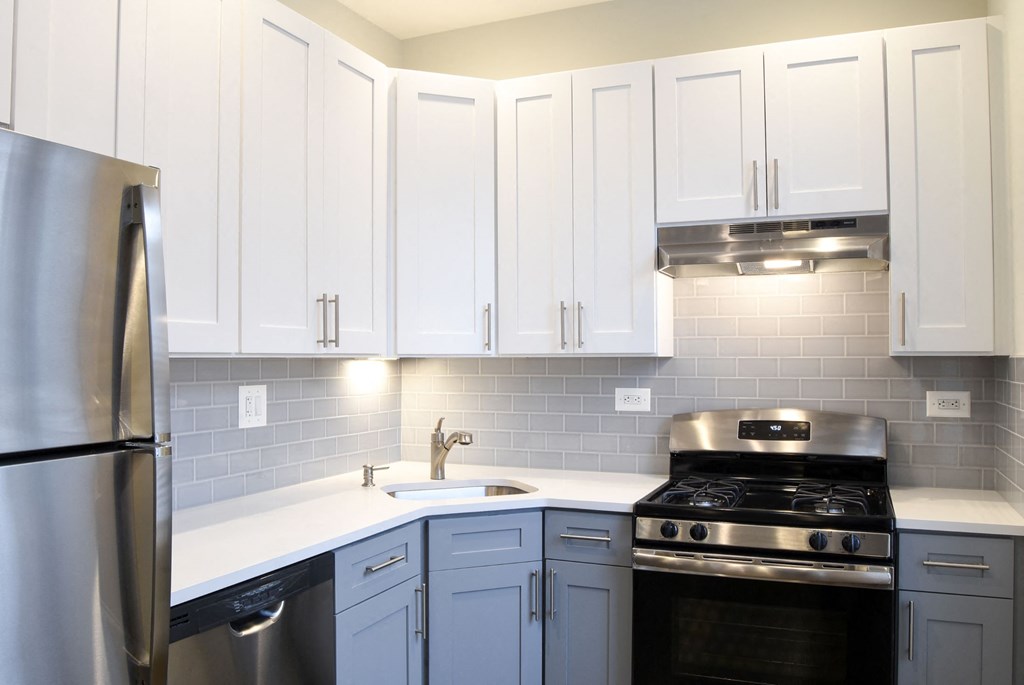a white kitchen with stainless steel appliances and white cabinets