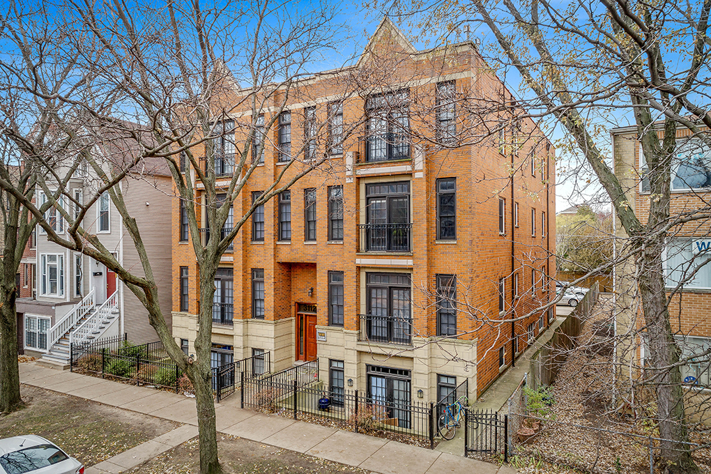 a brick building with a lot of trees in front of it