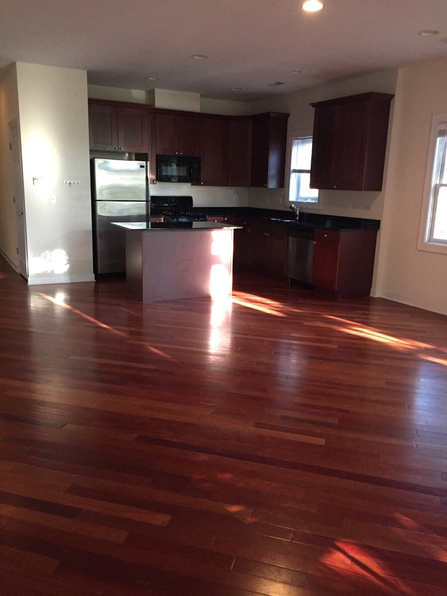 an empty living room with a hard wood floor